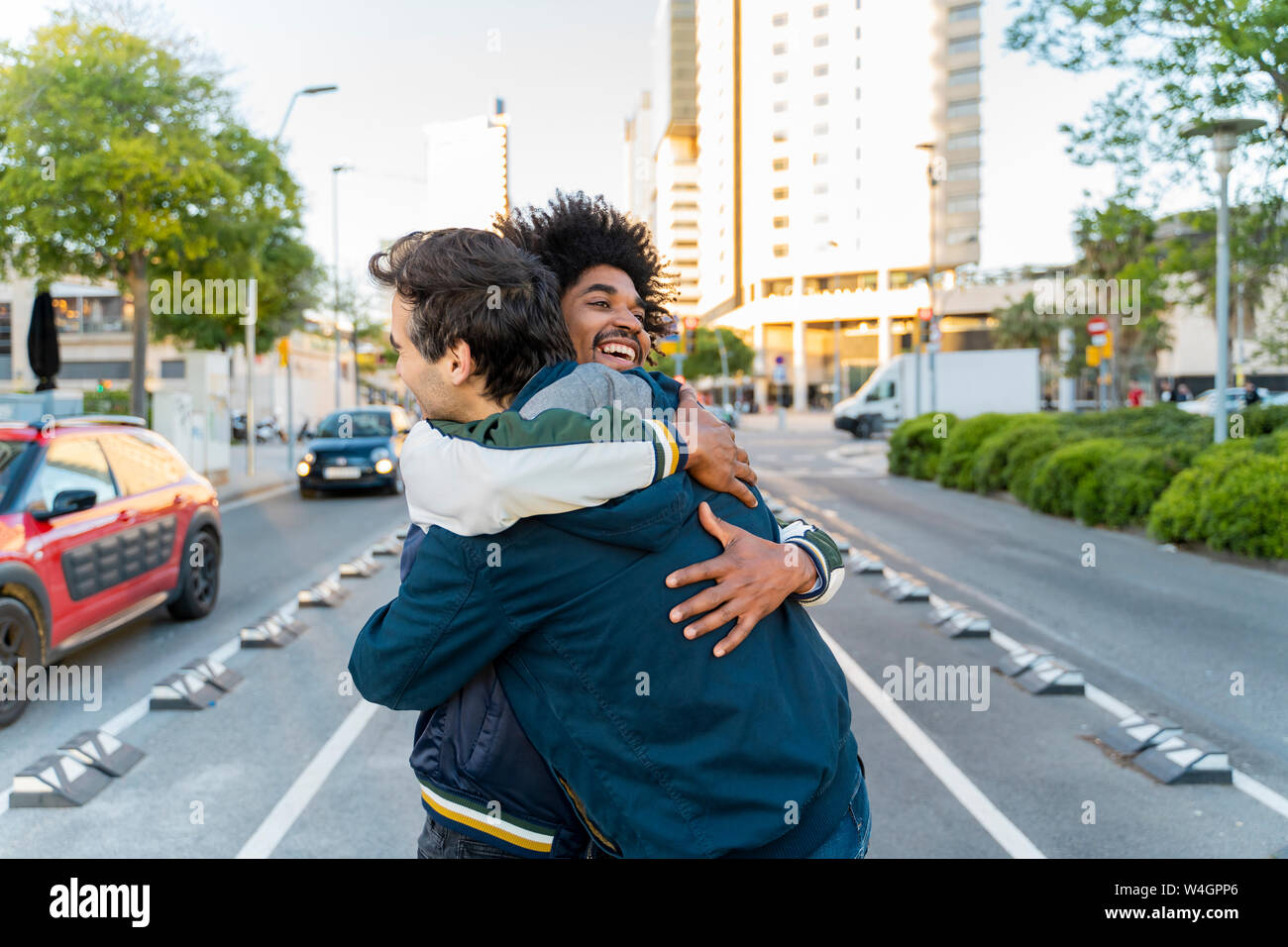 Two happy friends embracing in the city, Barcelona, Spain Stock Photo