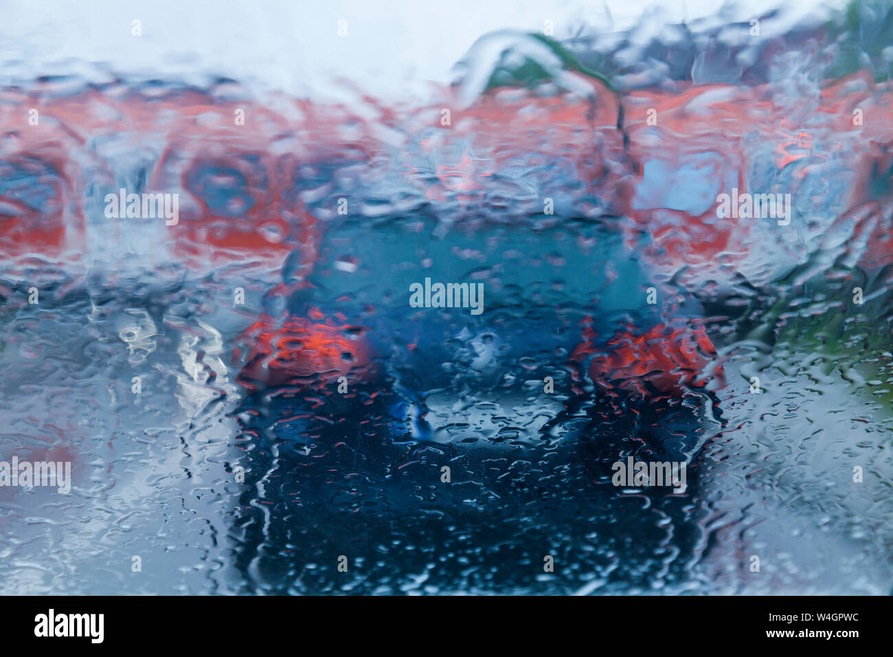 View through windscreen on rainy evening while waiting at level crossing Stock Photo