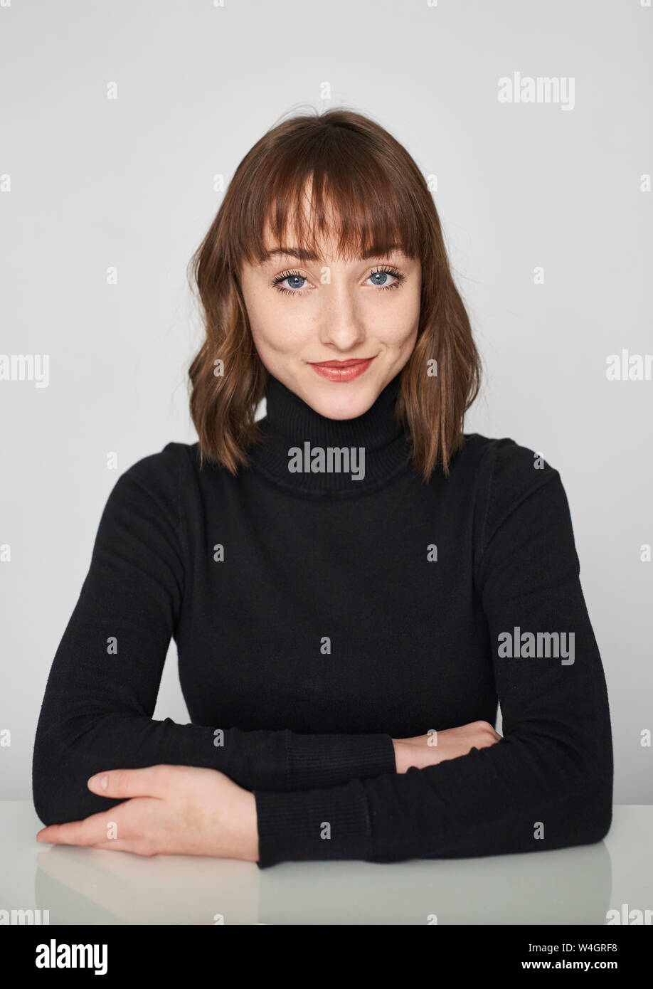 Portrait of smiling young woman wearing black turtleneck pullover Stock Photo