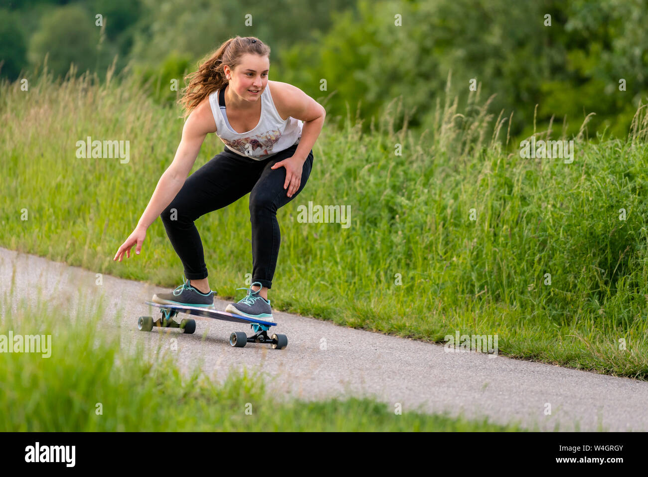 Young woman riding longboard Stock Photo