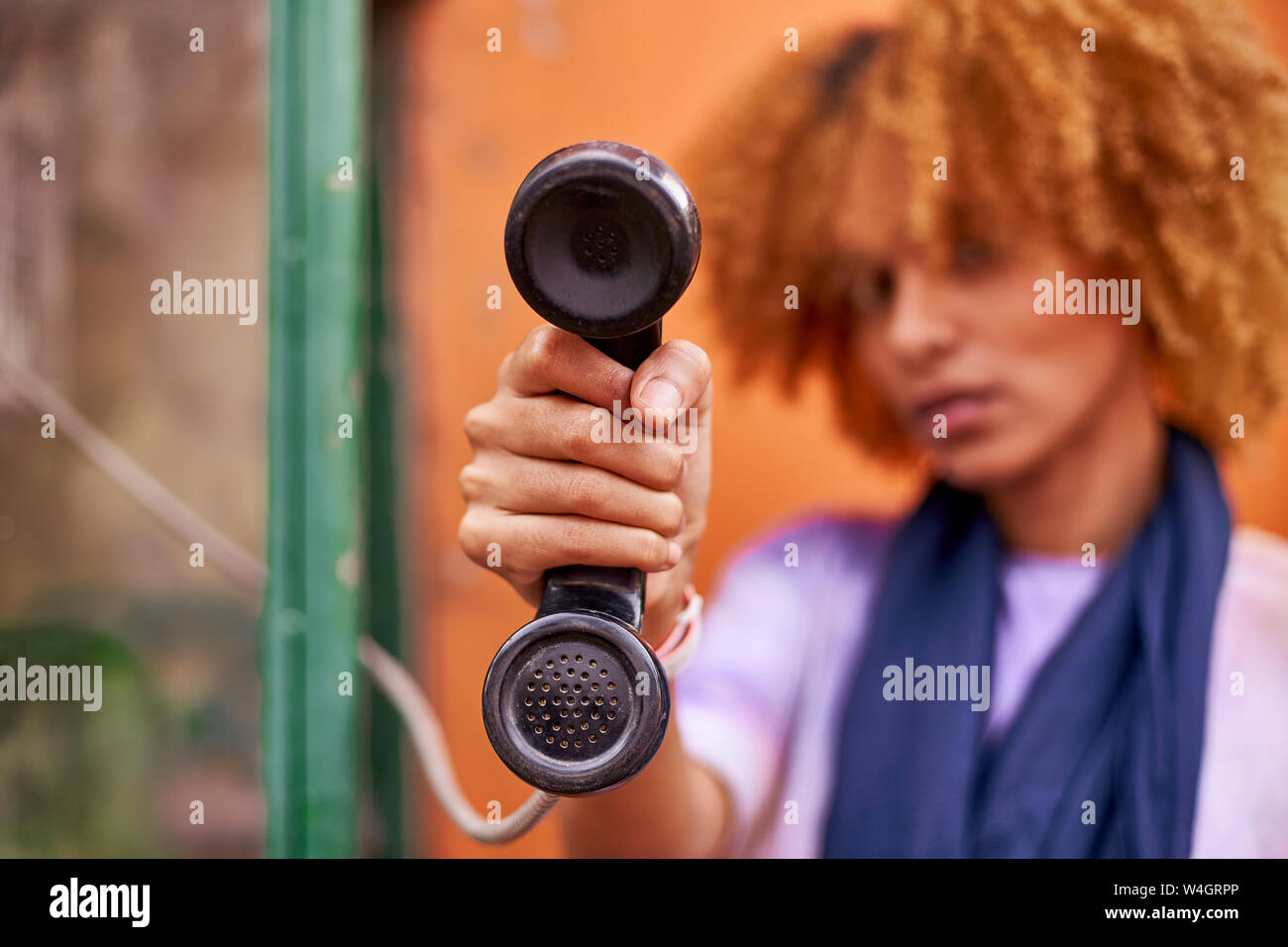 Woman holding old-fashioned telephone receiver Stock Photo