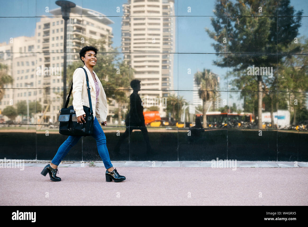 Woman with laptop bag walking Stock Photo