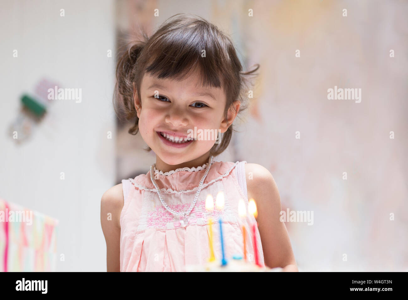 Portrait of happy little girl with burning candles on birthday cake Stock Photo