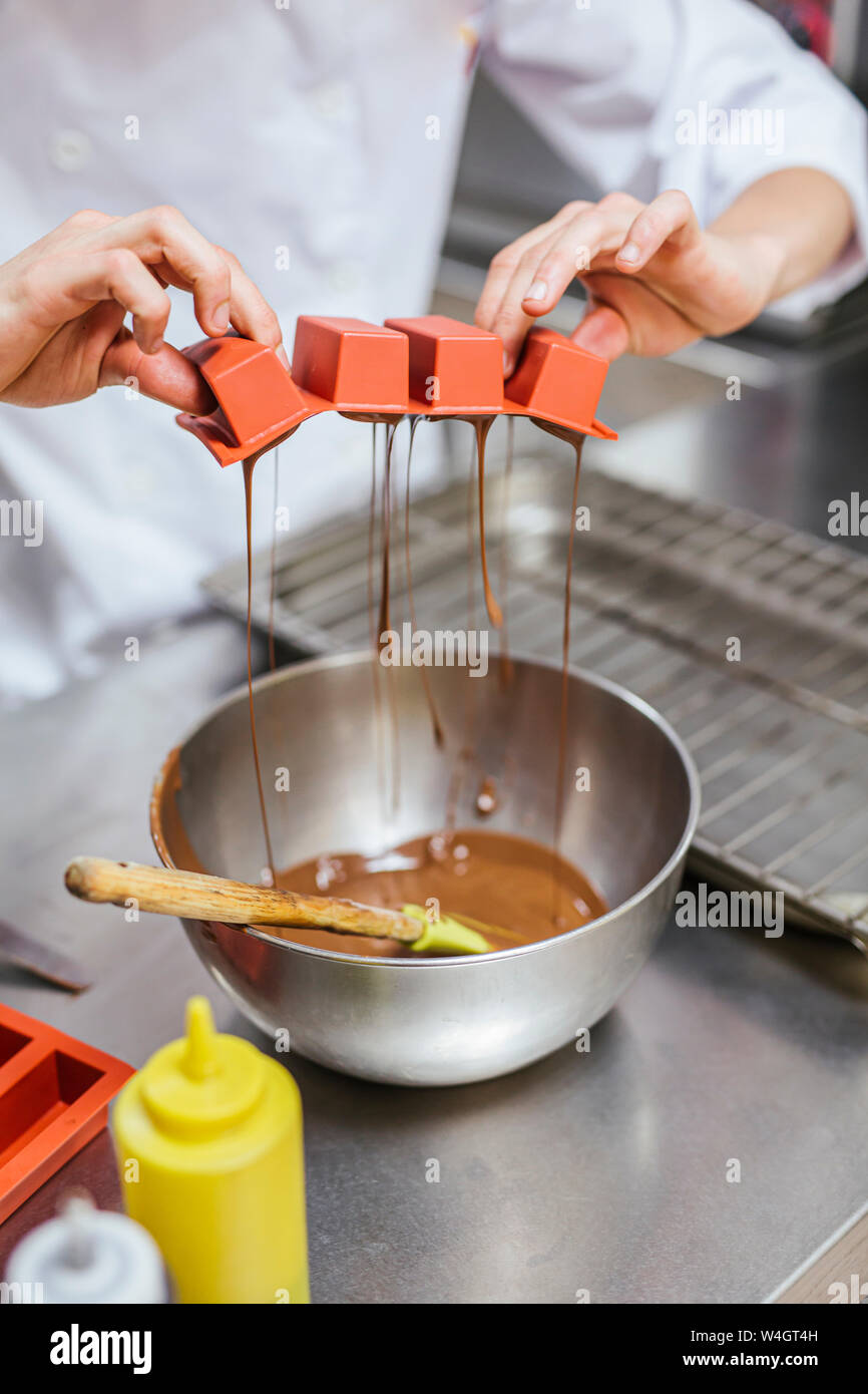 Junior chef prepairing a dessert, bowl with chocolate sauce Stock Photo