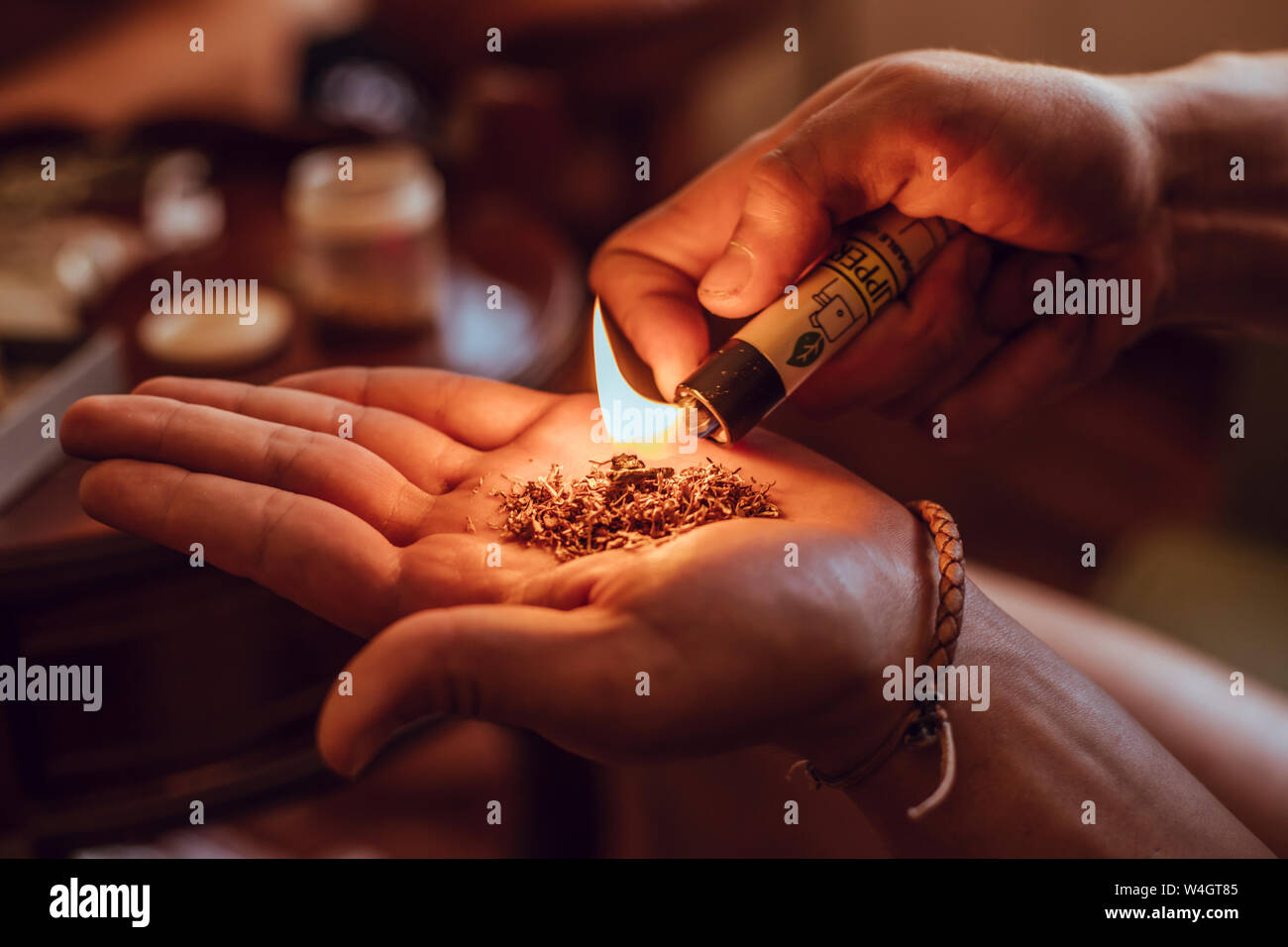 Close-up of hands burning tobacco and hashish with a lighter Stock Photo