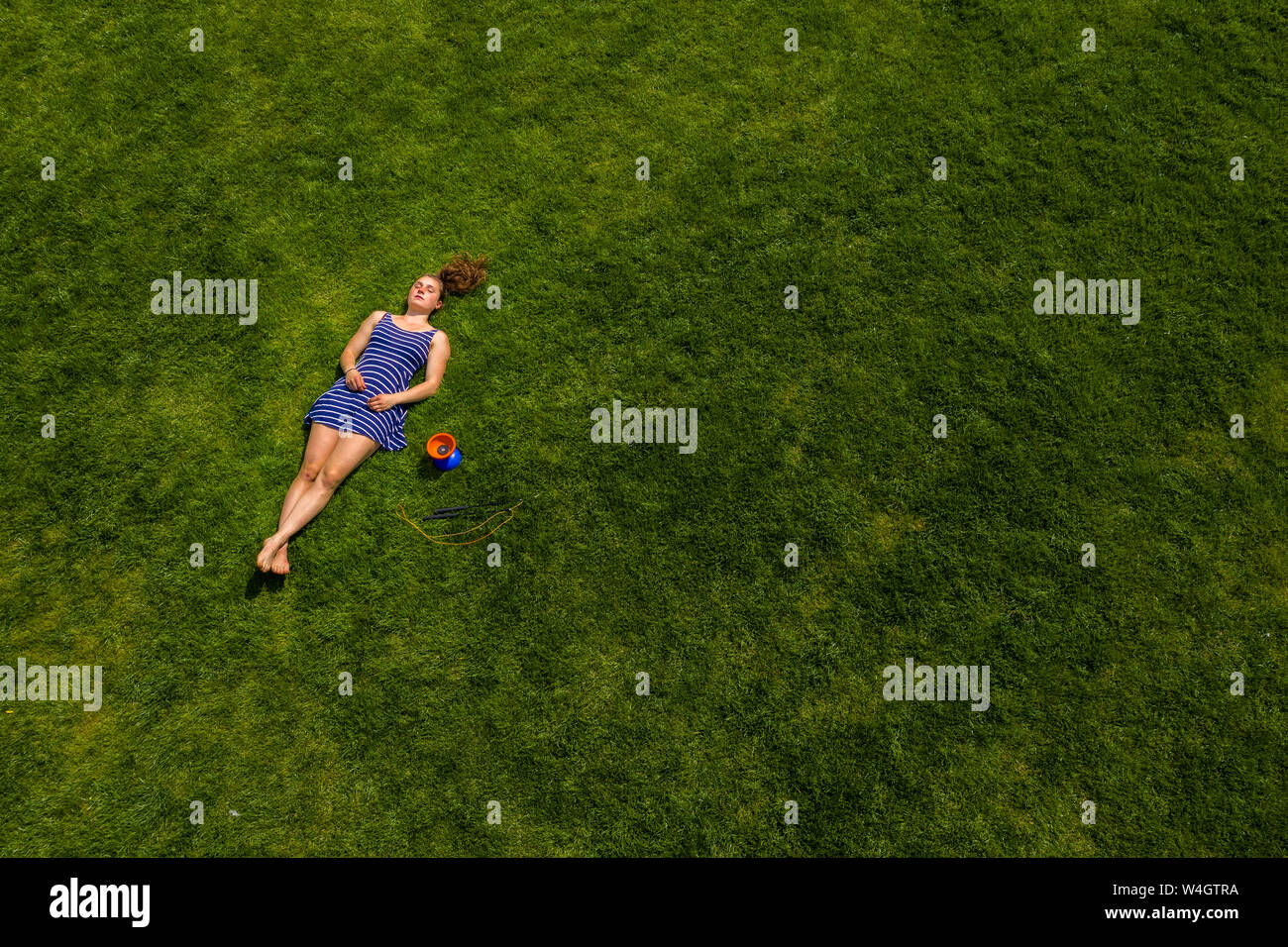 Aerial view of a young woman lying on a meadow Stock Photo