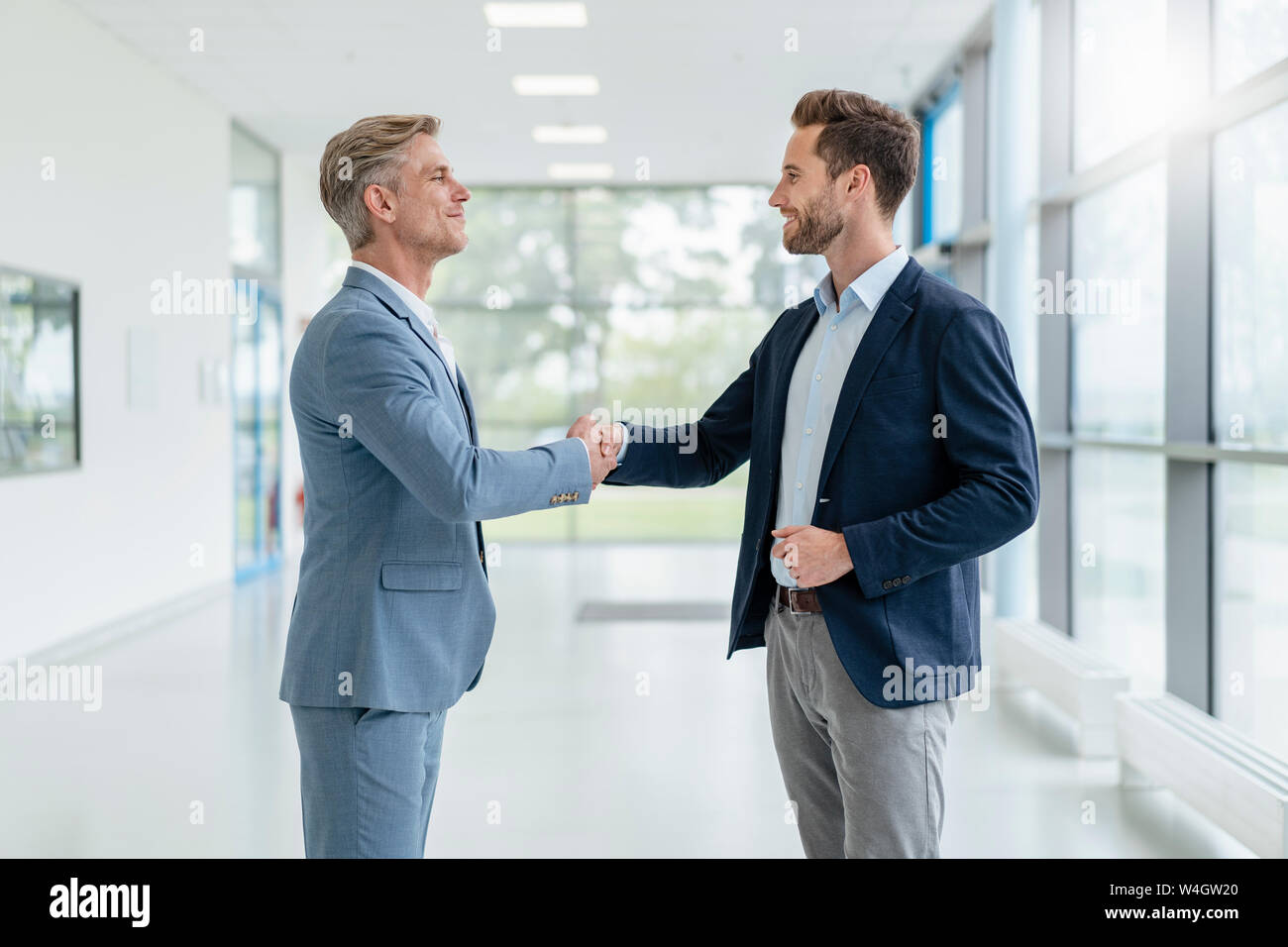 Two businessmen shaking hands in a passageway Stock Photo