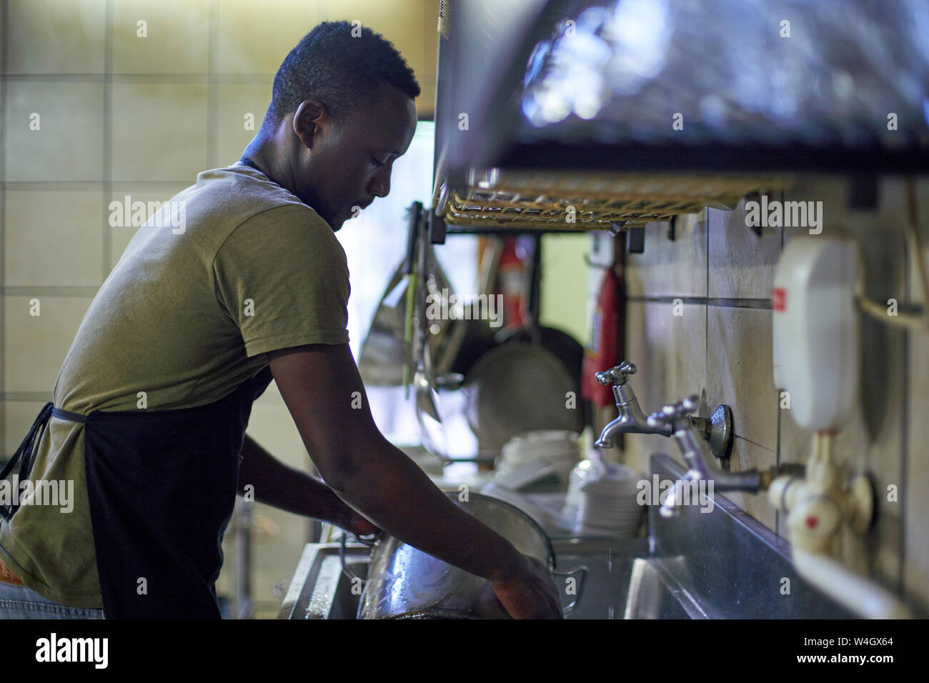 https://c8.alamy.com/comp/W4GX64/young-man-washing-dishes-in-restaurant-kitchen-south-africa-W4GX64.jpg