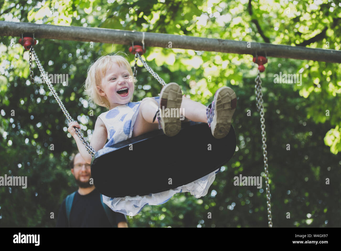 Portrait of happy ltiitle girl on a swing Stock Photo