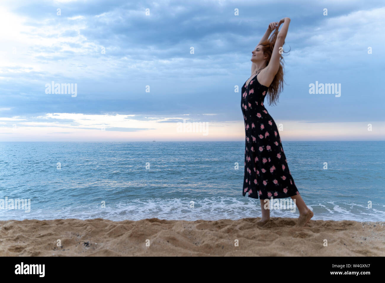 Happy young woman dancing on the beach in the evening Stock Photo - Alamy
