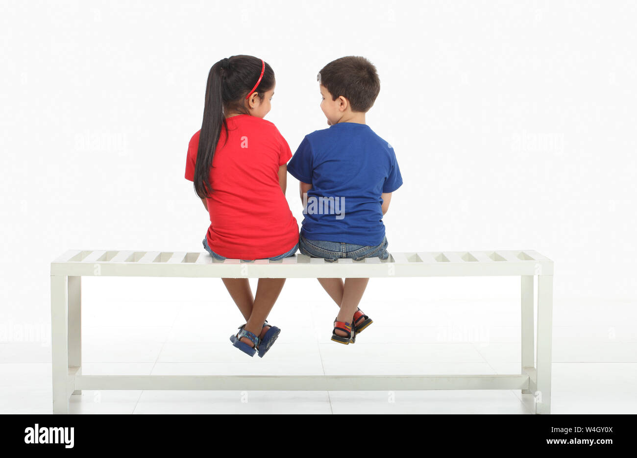 Rear view of two children sitting on a bench Stock Photo - Alamy