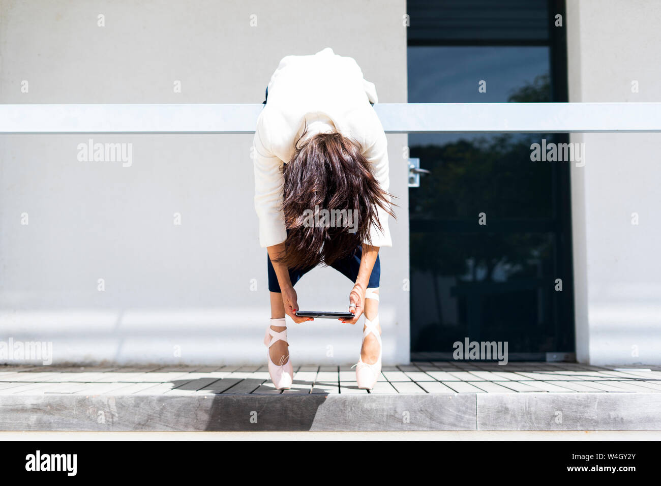 Female ballet dancer hanging over railing hi-res stock photography and