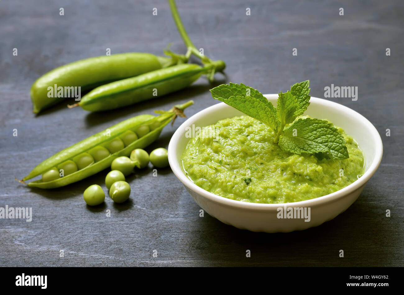 Pesto sauce with basil and green peas in white bowl Stock Photo