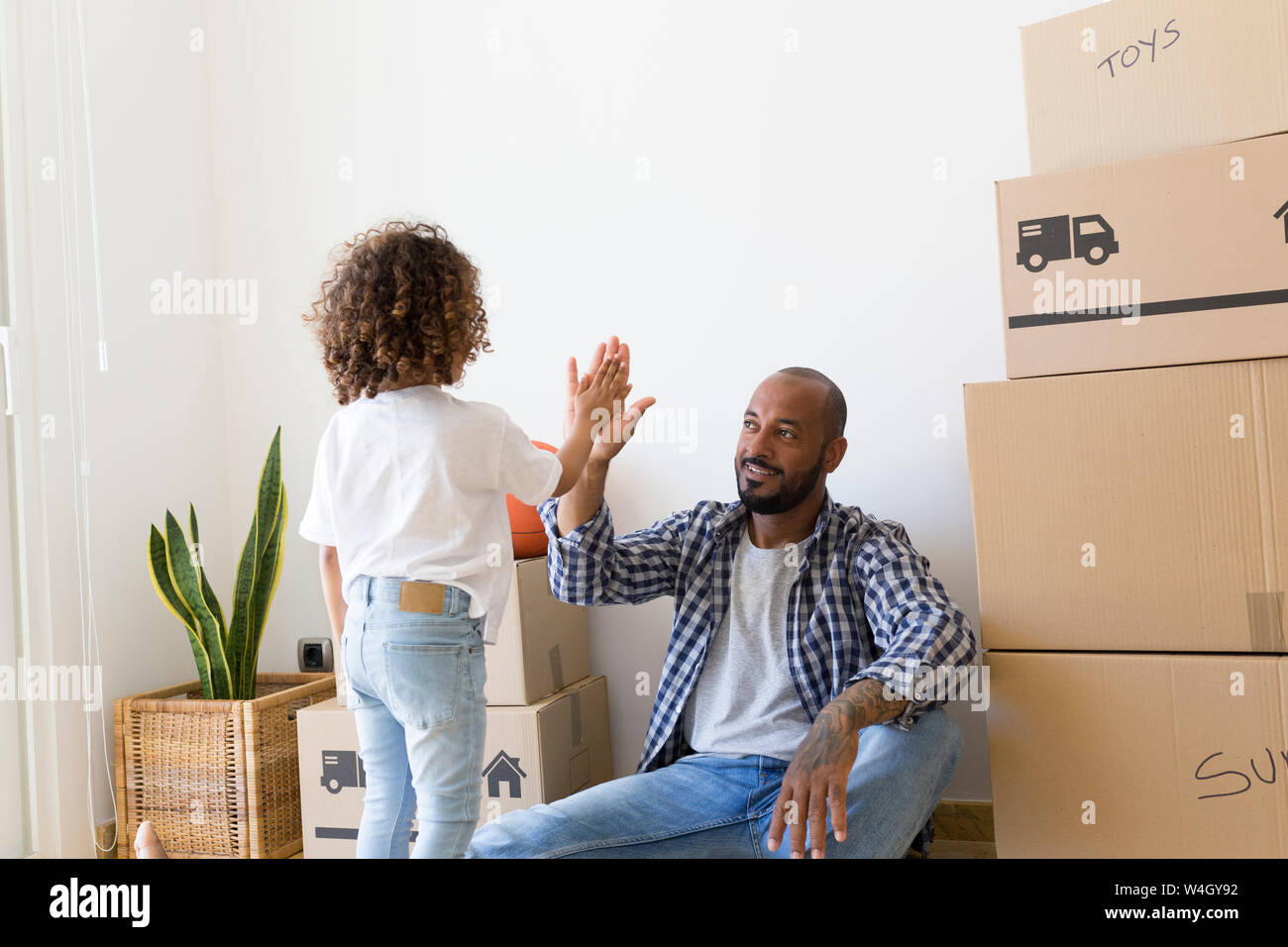Father and daughter high fiving at new home Stock Photo