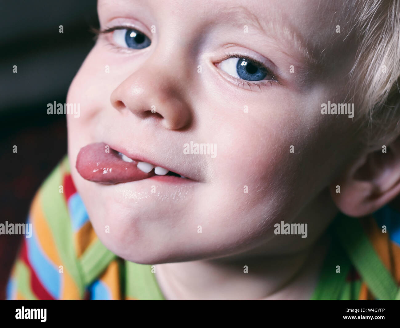 Portrait of little boy sticking out tongue Stock Photo