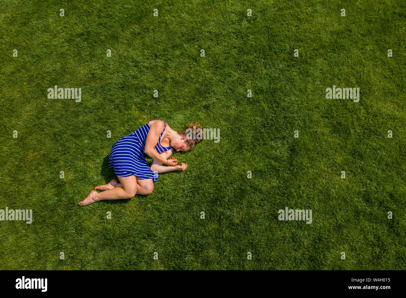 Aerial view of a young woman lying on a meadow Stock Photo