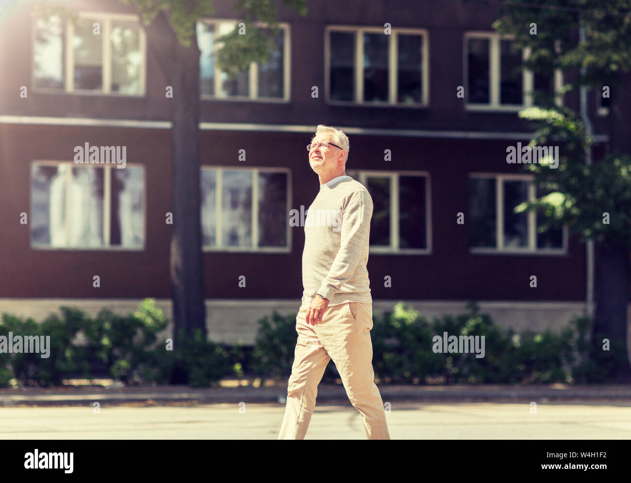 Old man walking along street hi-res stock photography and images - Alamy