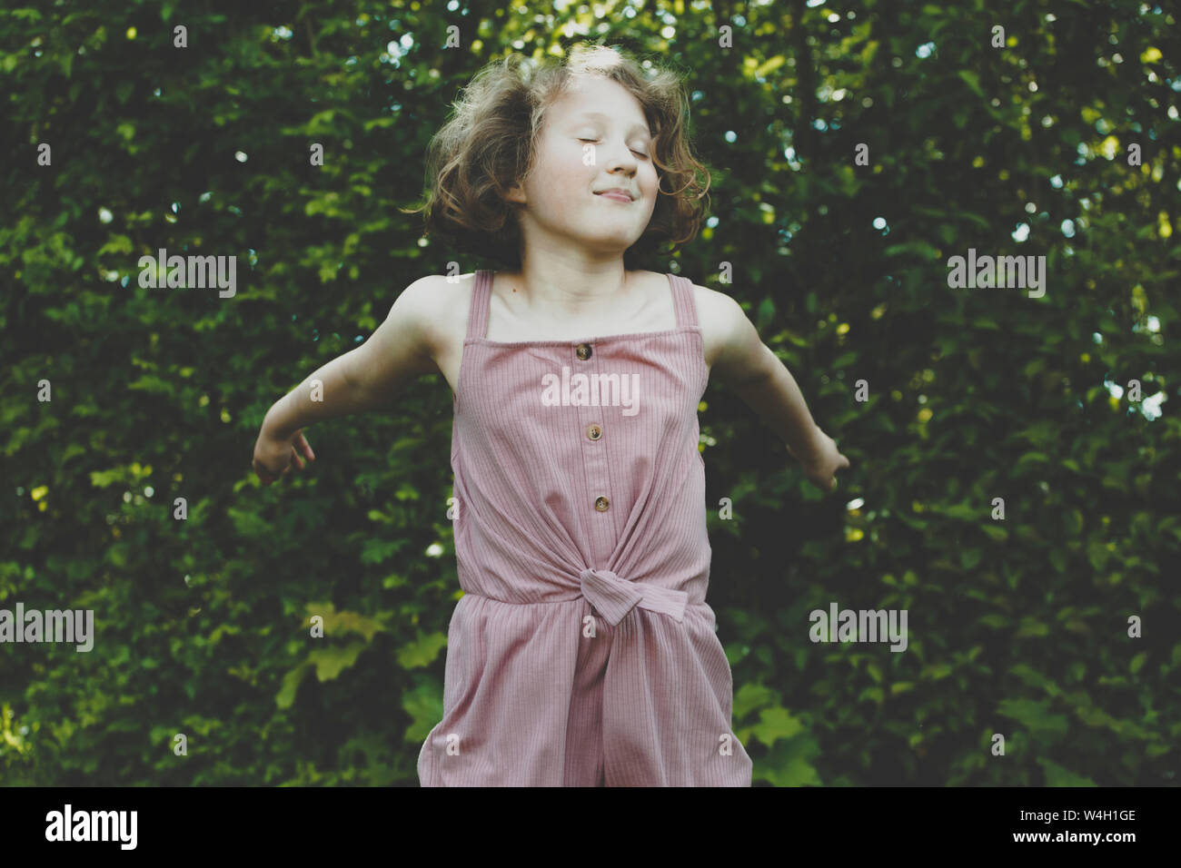 A girl jumping with eyes closed Stock Photo