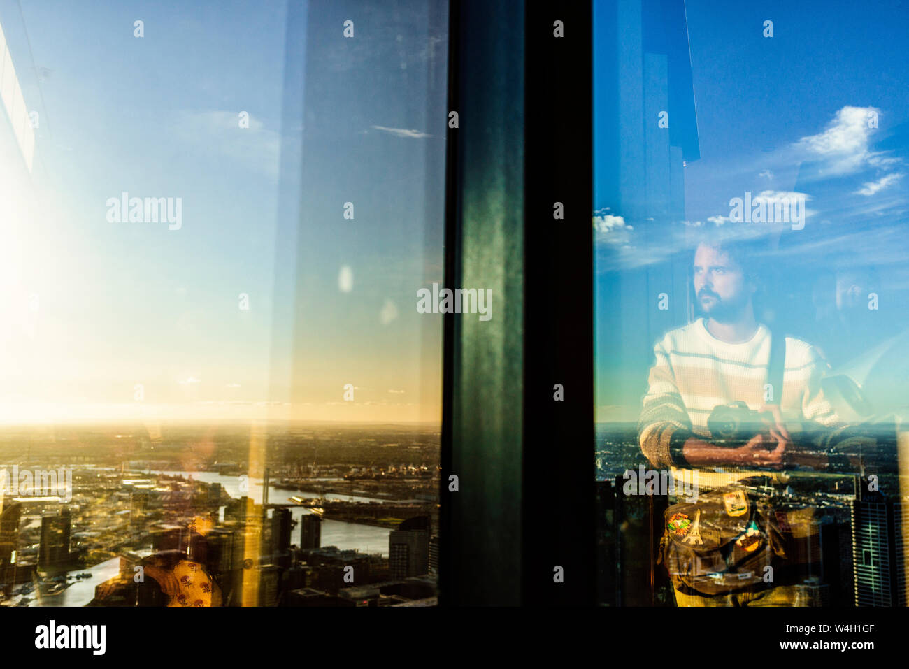 Reflection of man in glass with cityscape of Melbourne, Victoria, Australia Stock Photo