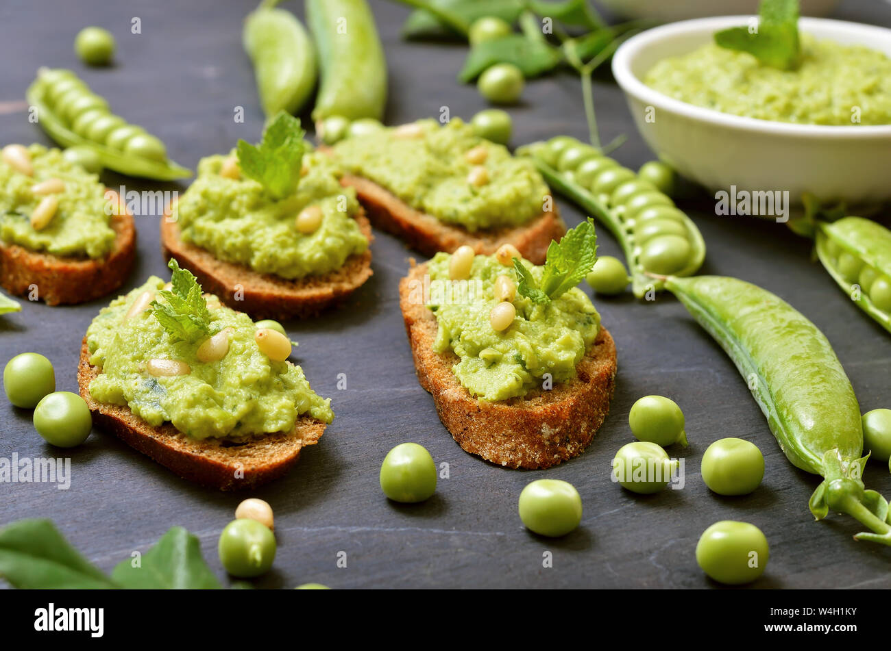 Sandwiches with pesto sauce and pine nuts. Fresh green peas, close up Stock Photo