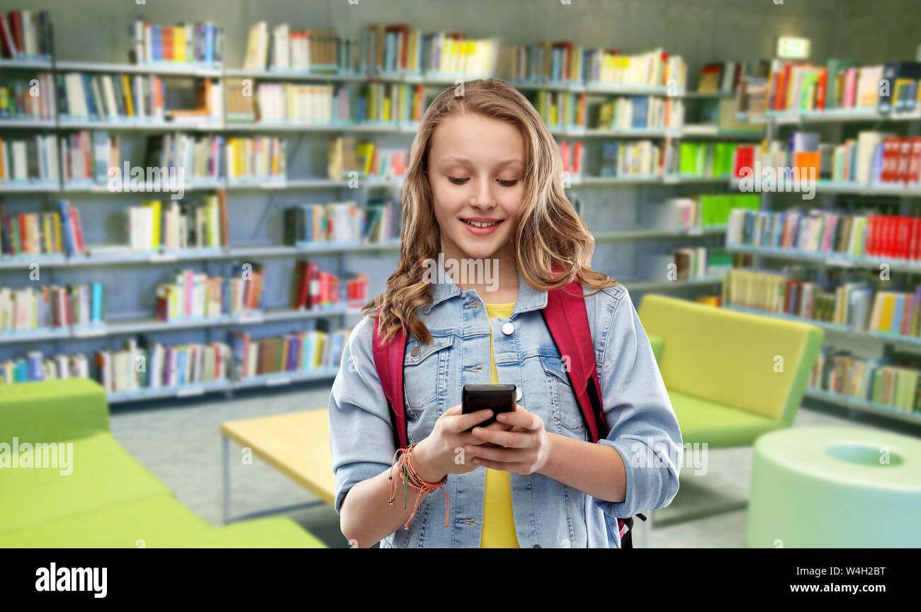 teenage student girl with smartphone at library Stock Photo - Alamy