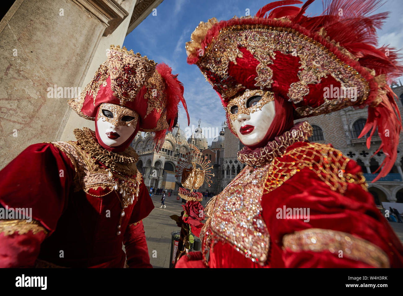 Venetian Masks in red costumes in Venice Italy Stock Photo