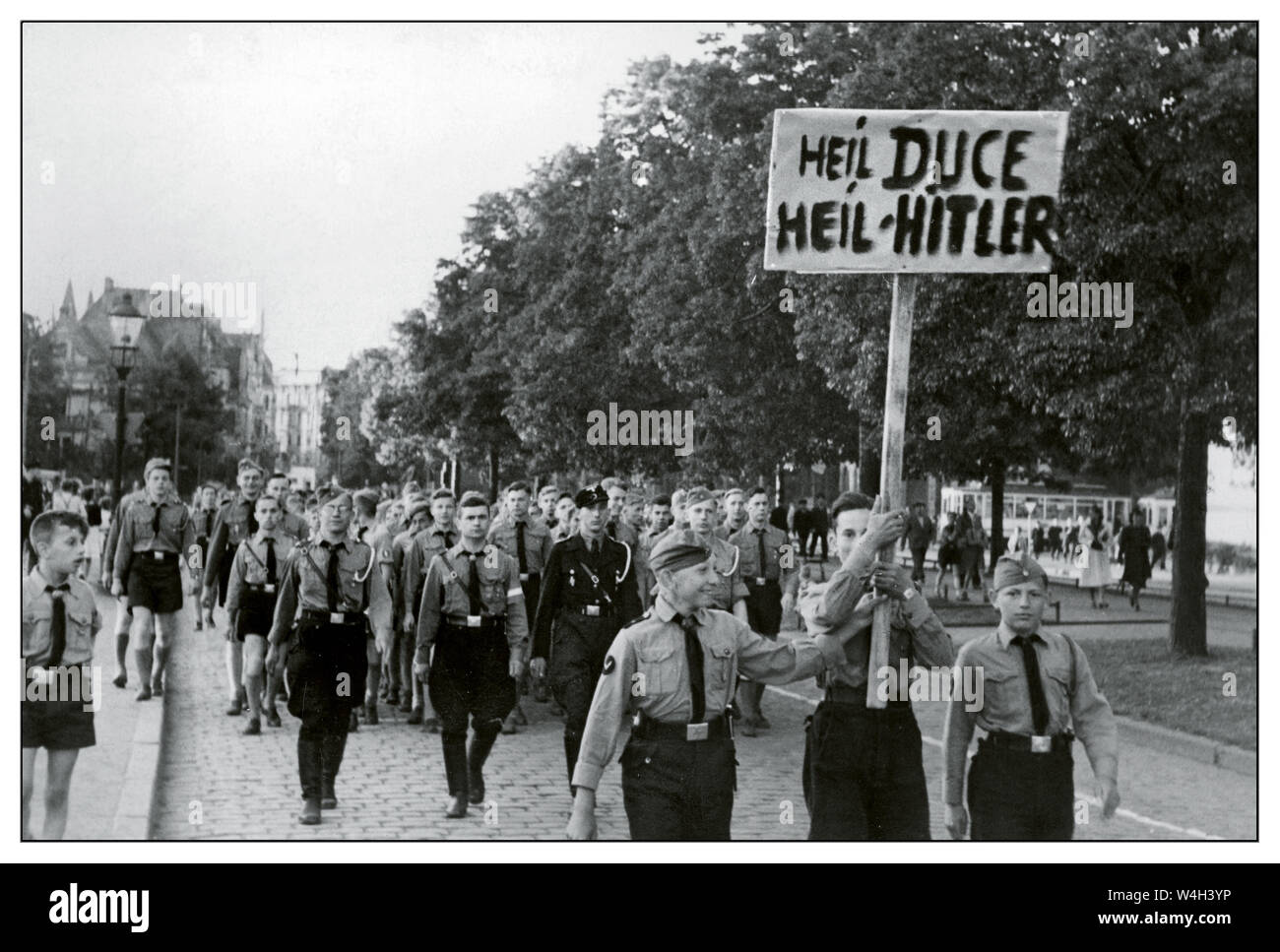 Vintage 1940's Nazi Hitler Youth March demonstration of Hitlerjugend on Gdansk city street.  'Heil Duce, Heil Hitler' banner. Showing support for Mussolini and Hitler 1940's Gdańsk Poland Stock Photo