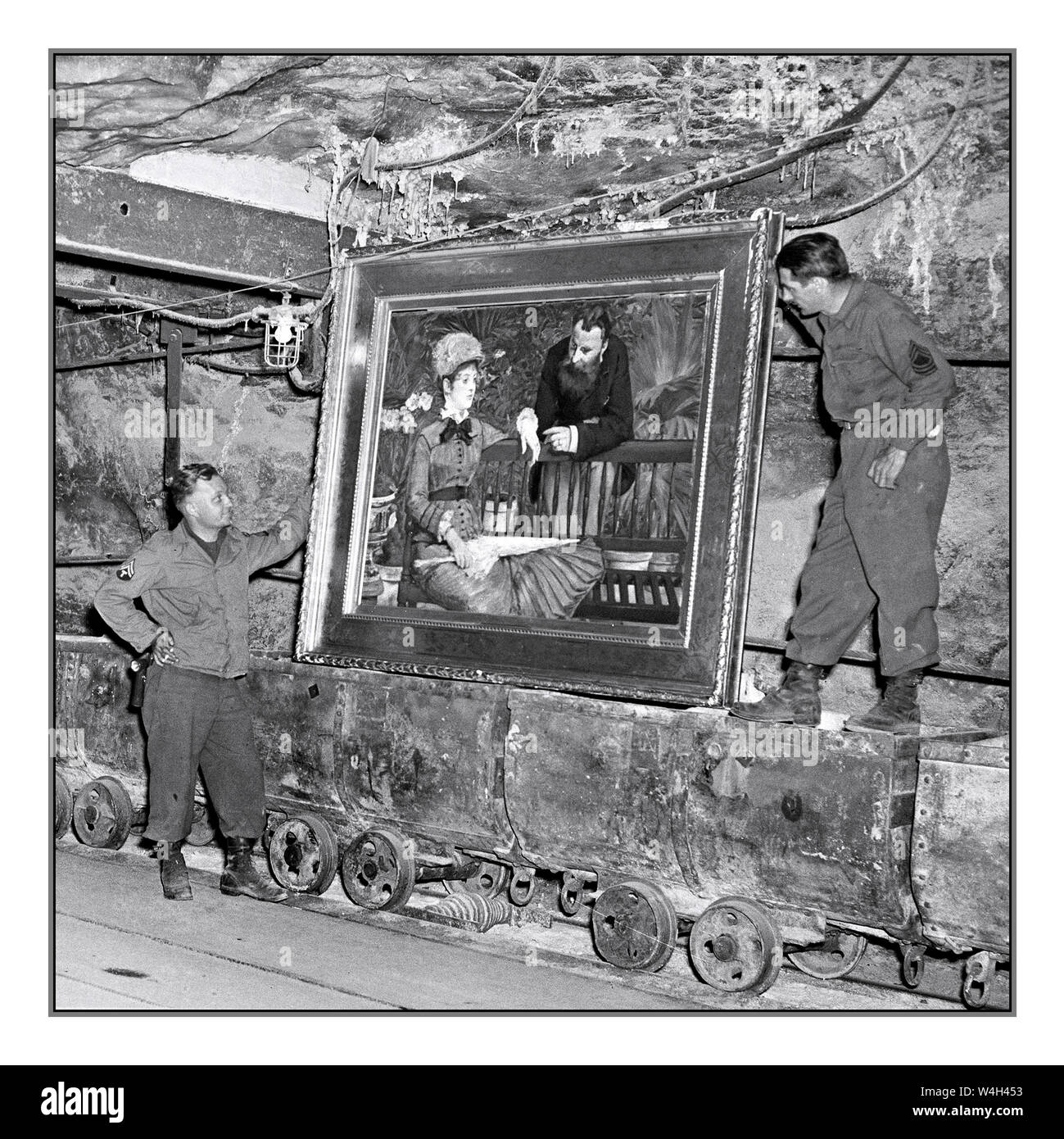 Vintage post-WW2 Nazi Loot found at Merkers, Germany U.S. Soldiers examine a famous painting, 'In the Winter Garden' by MANET, Edouard' by the French Impressionist Edouard Manet, in the collection of Reichbank wealth, SS loot, and paintings removed by the Nazis from Berlin to a salt mine vault. The 90th Div, U.S. Third Army, discovered the gold and other treasure. 04/15/45 Photographer: Cpl. Ornitz Stock Photo