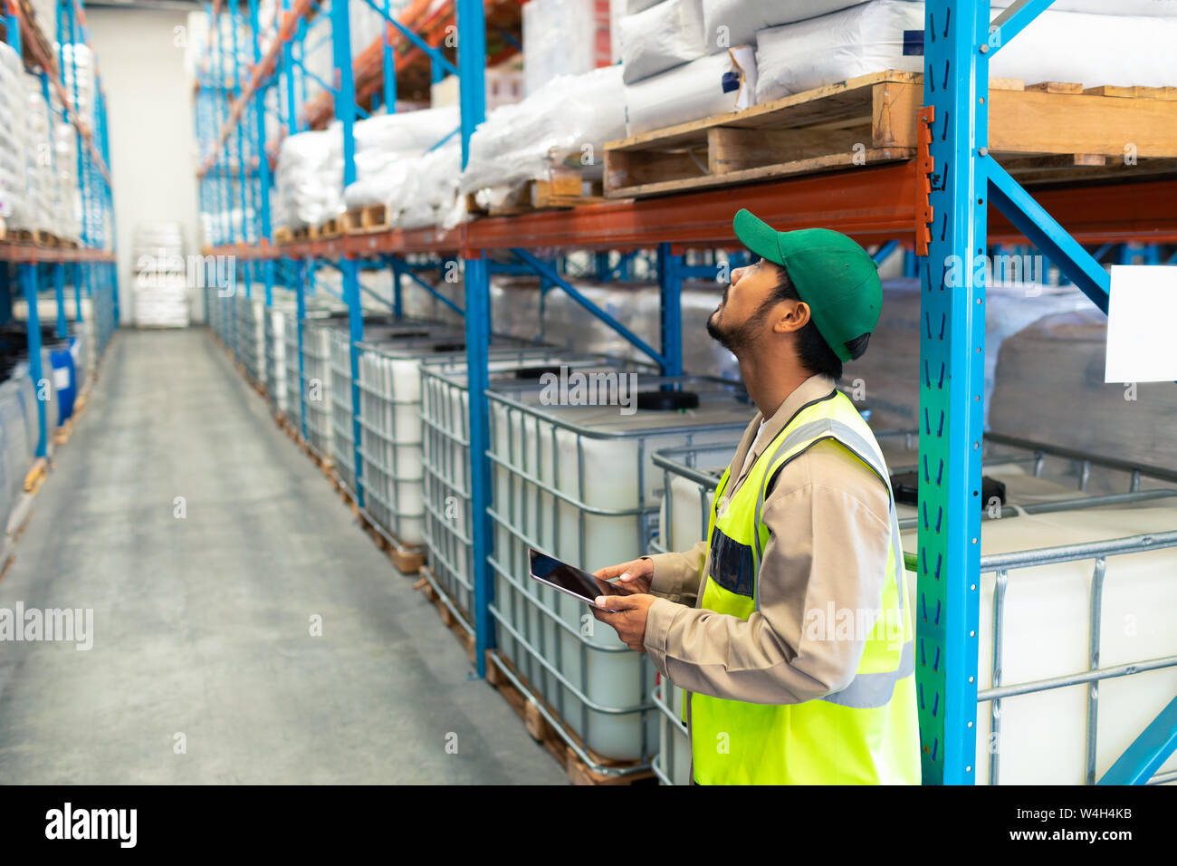 Male worker with digital tablet working in warehouse Stock Photo