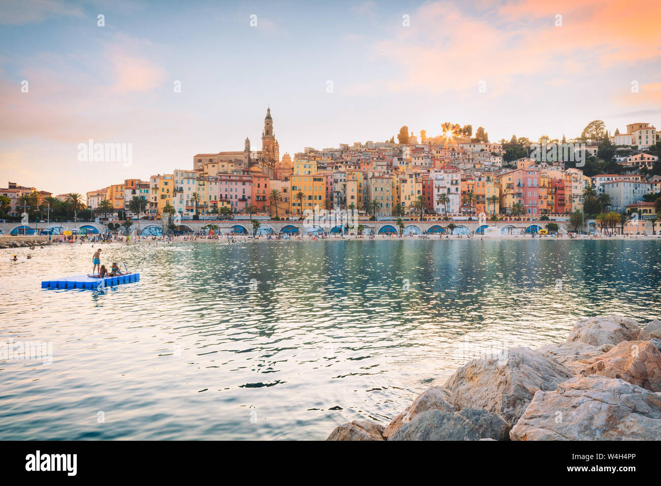 Public beach of Menton old town at sunset Stock Photo