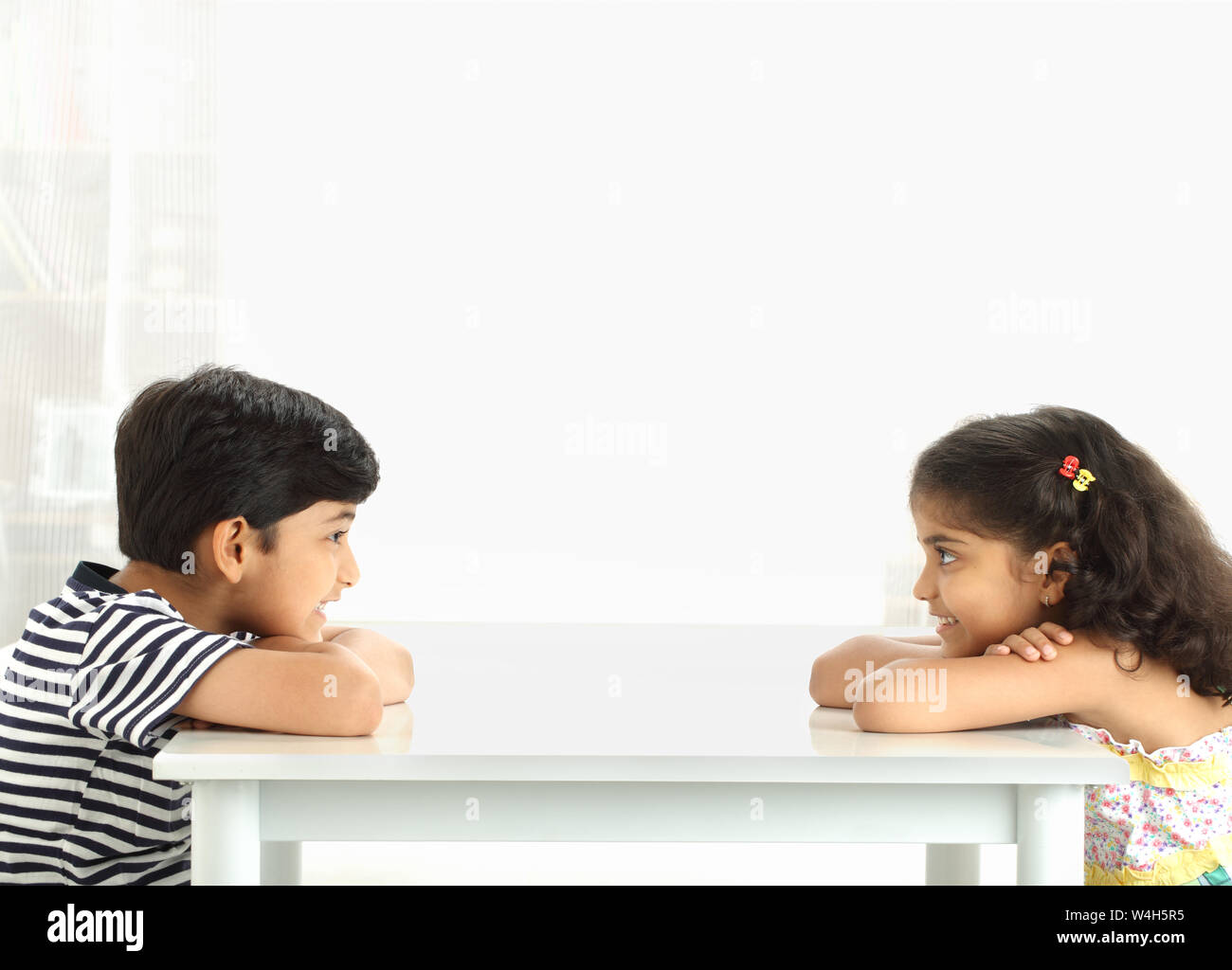 Two children playing eye contact game and smiling Stock Photo Alamy