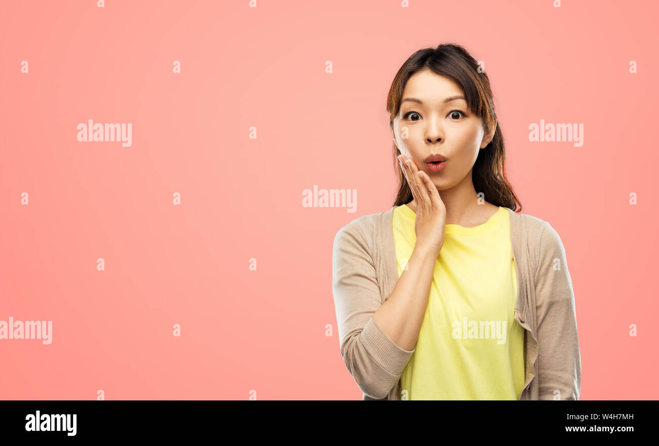 surprised asian woman over grey background Stock Photo - Alamy