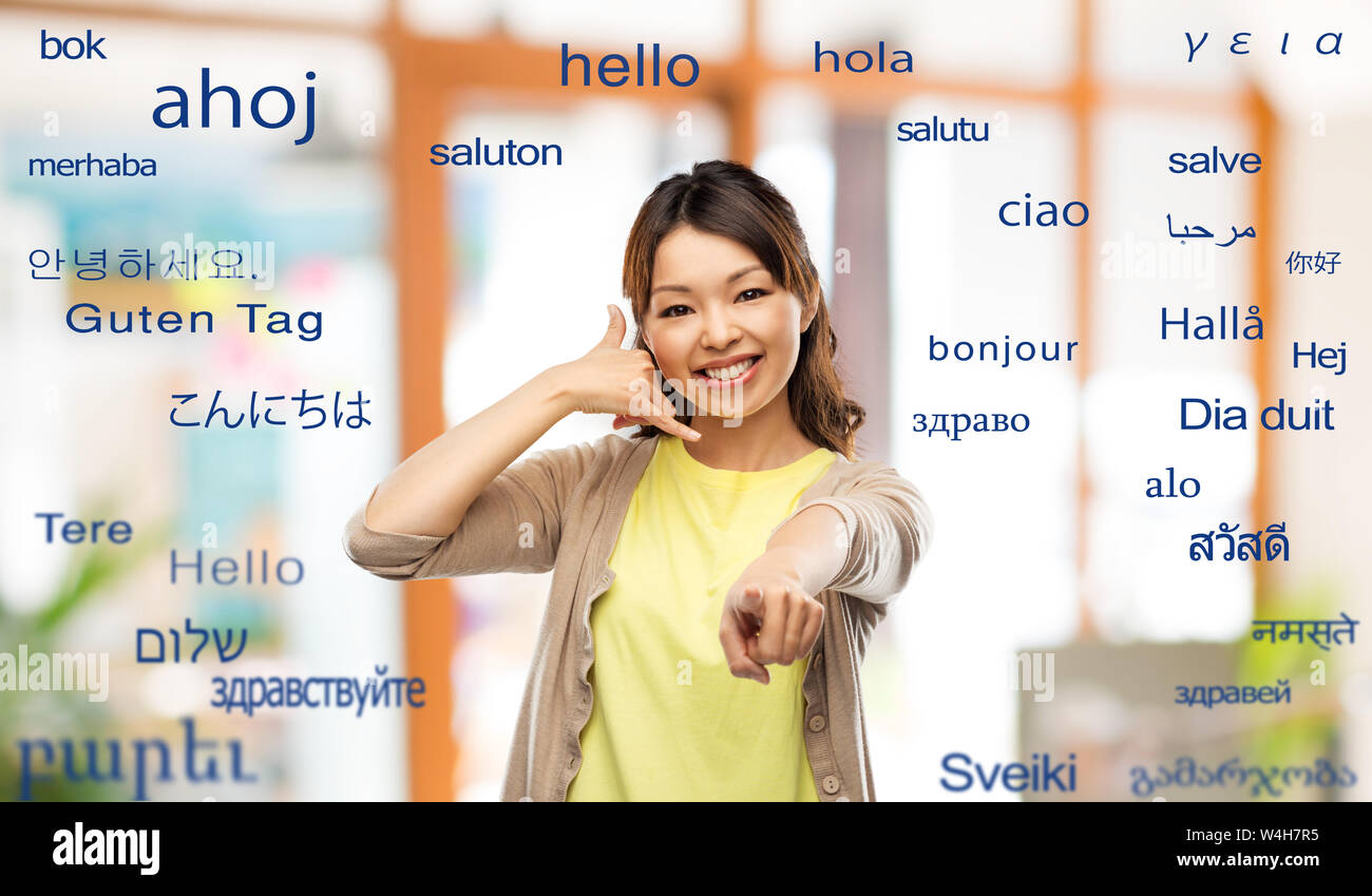 woman making phone call gesture over foreign words Stock Photo