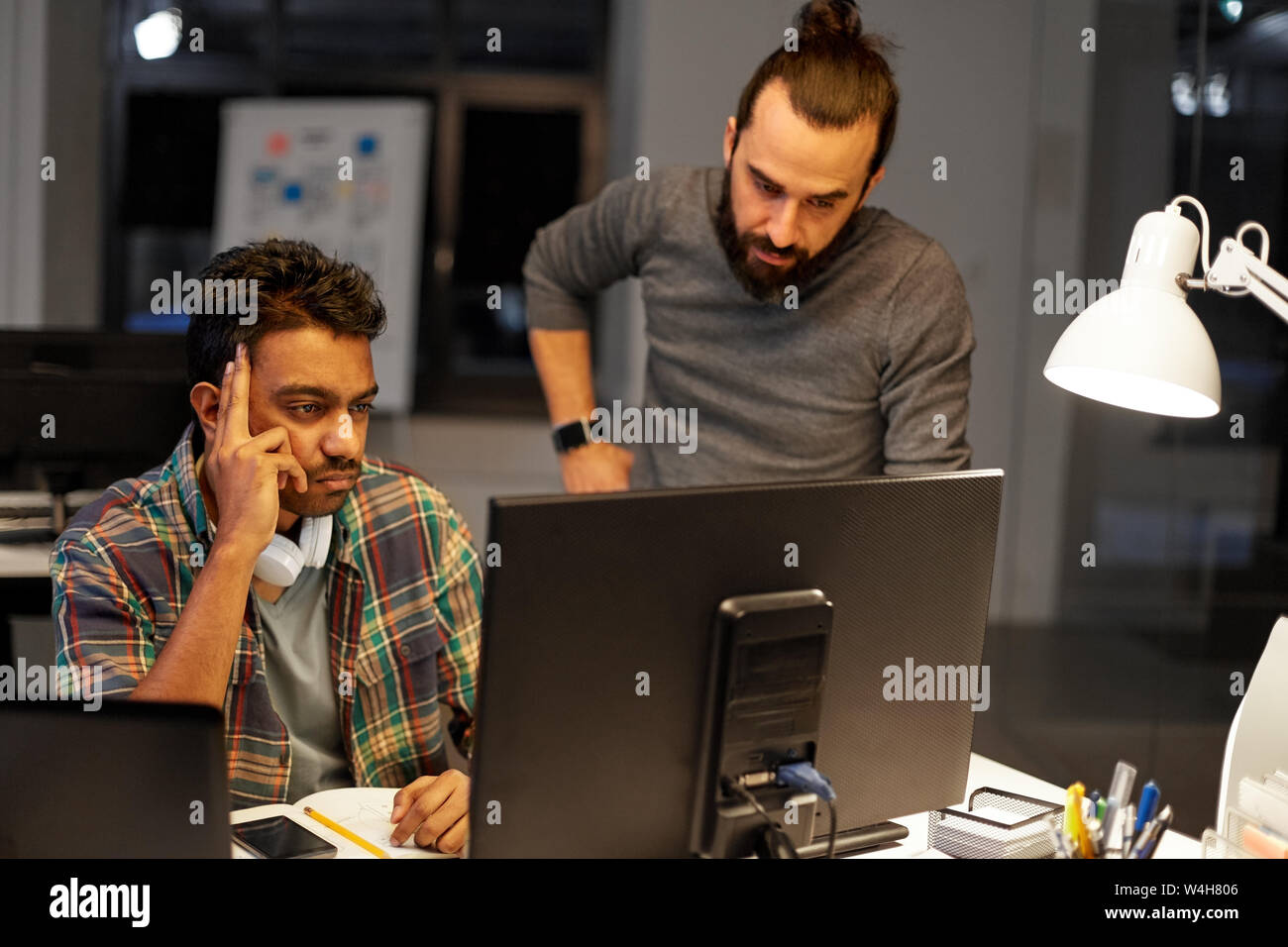 creative team with computer working late at office Stock Photo