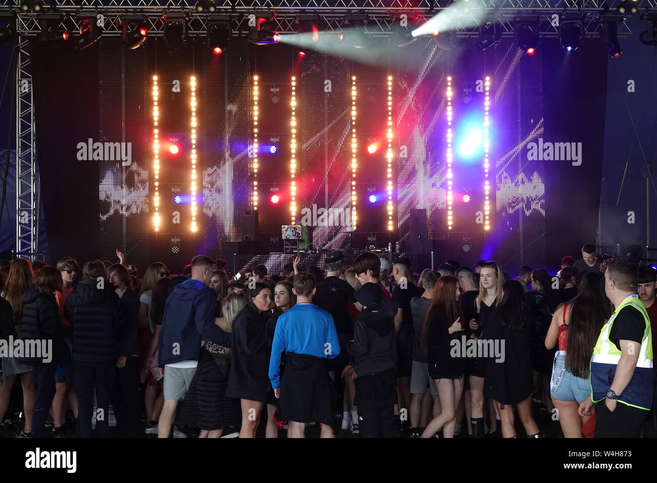 Teenagers listening to rave music in a big marque at an outdoor music  festival Stock Photo - Alamy