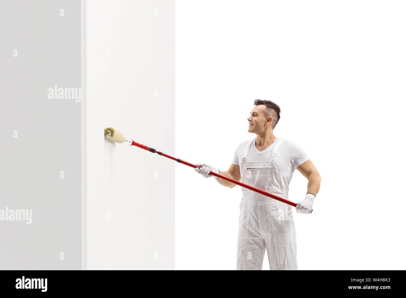 Painter painting a wall with a roller isolated on white background Stock Photo