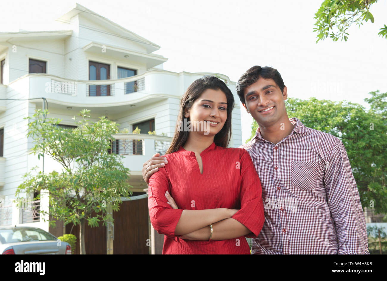 Portrait of a Indian couple smiling with home in the background Stock Photo  - Alamy