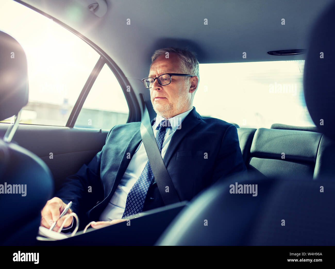 senior businessman with papers driving in car Stock Photo - Alamy