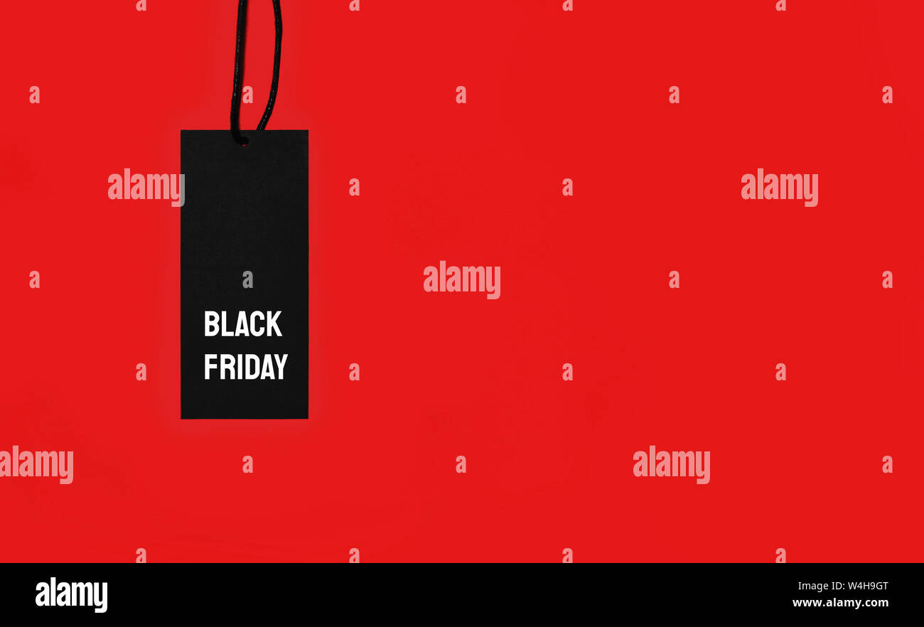 Black sale tag with Black Friday inscription on red background. Stock Photo