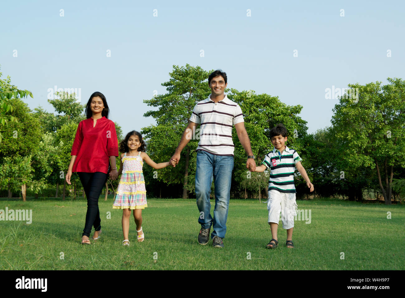 Family of four walking in a field hi-res stock photography and images ...