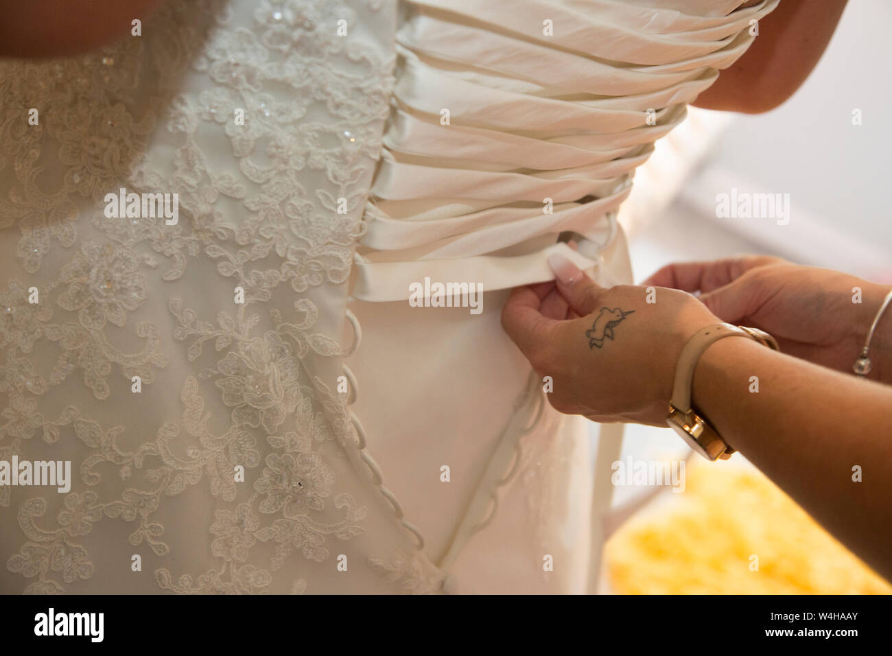 Wedding dress being done up on a Brides wedding day, close up of wedding dress being done up before the ceremony Stock Photo