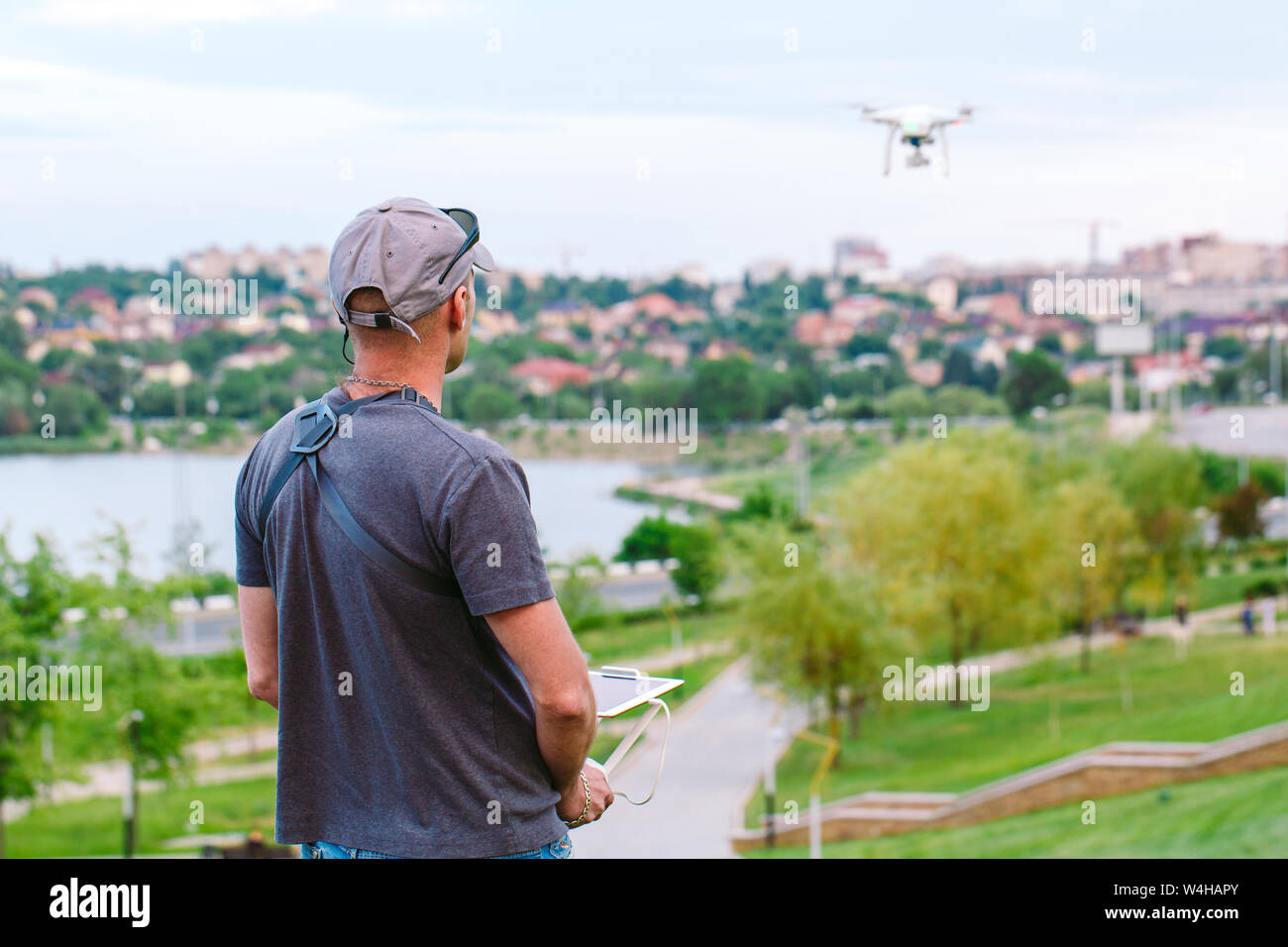 Young Man watching and navigating a flying drone. Stock Photo