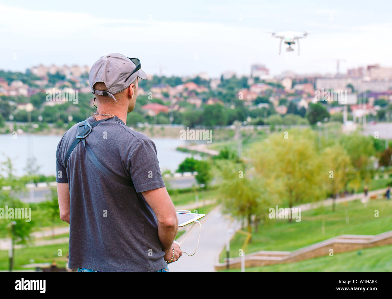 Young Man watching and navigating a flying drone. Stock Photo
