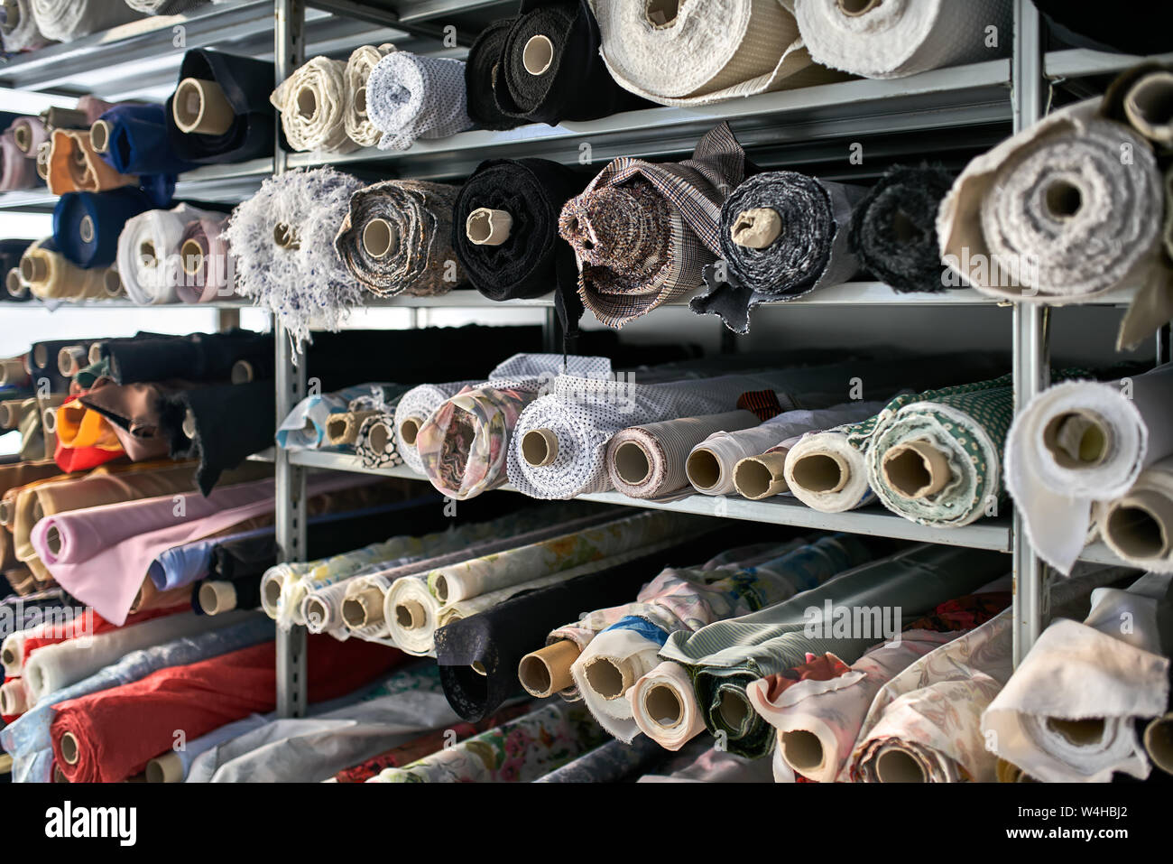 Fabric warehouse with many multicolored textile rolls Stock Photo - Alamy