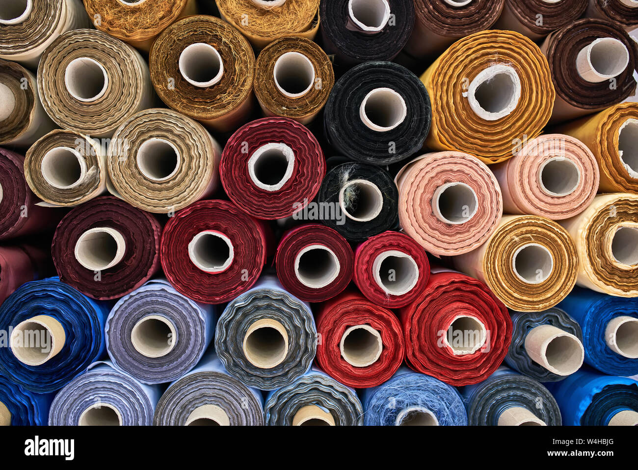 Fabric warehouse with many multicolored textile rolls Stock Photo