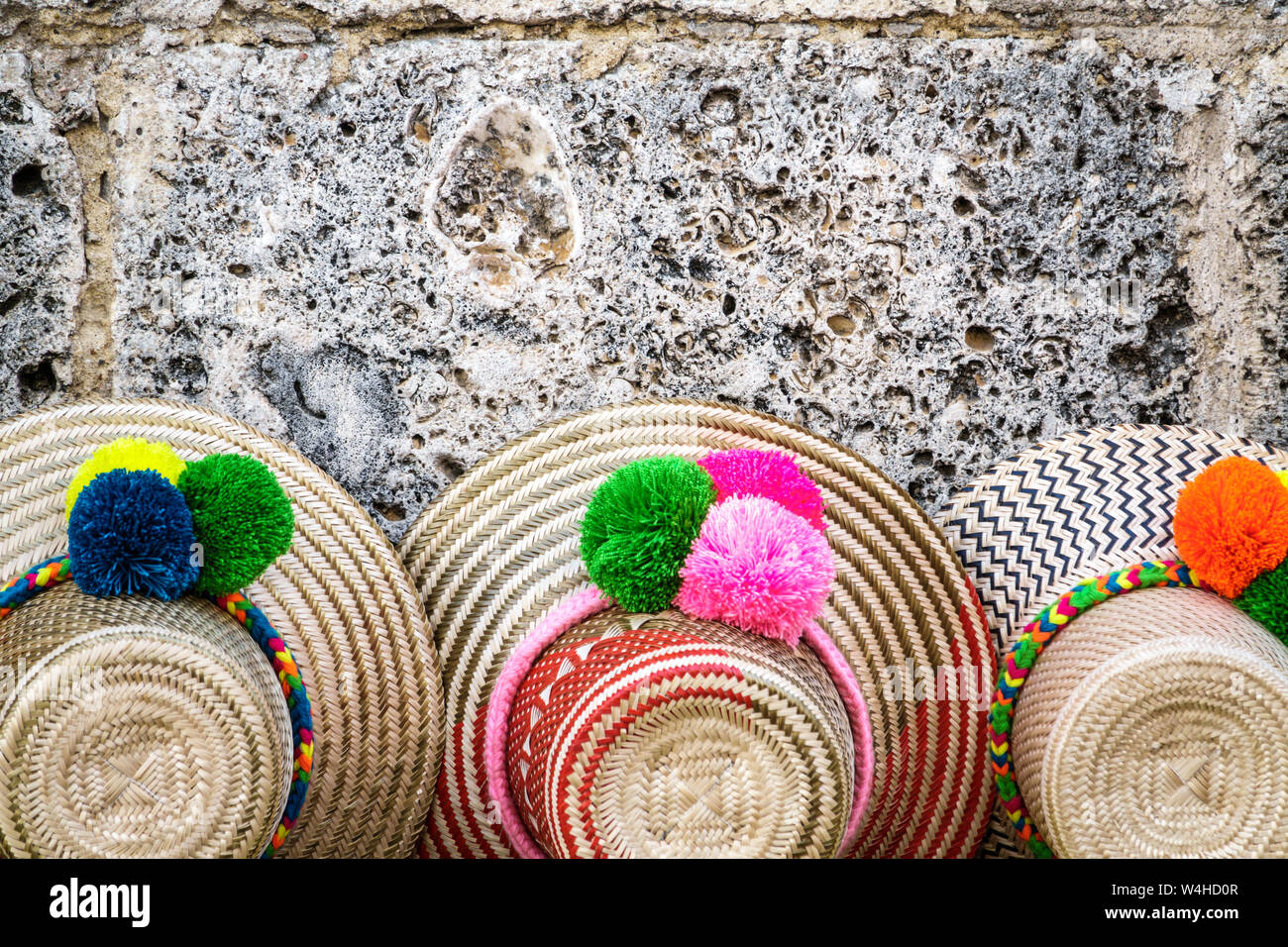 Colombia Cartagena Old Walled City Center centre street vendor display sale typical woven straw hats pom poms souvenirs sightseeing visitors tr Stock Photo