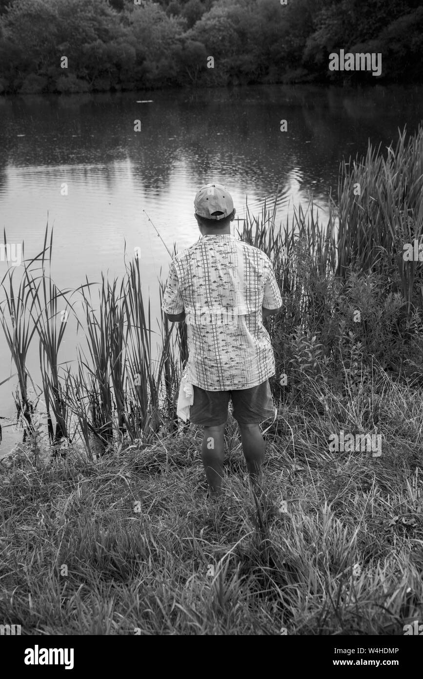 Reisetertown, MD, July 3, 2019,USA: A man enjoys the solitude found in fishing in a small pond in Reistertown, MD   Patsy Lynch photo Stock Photo