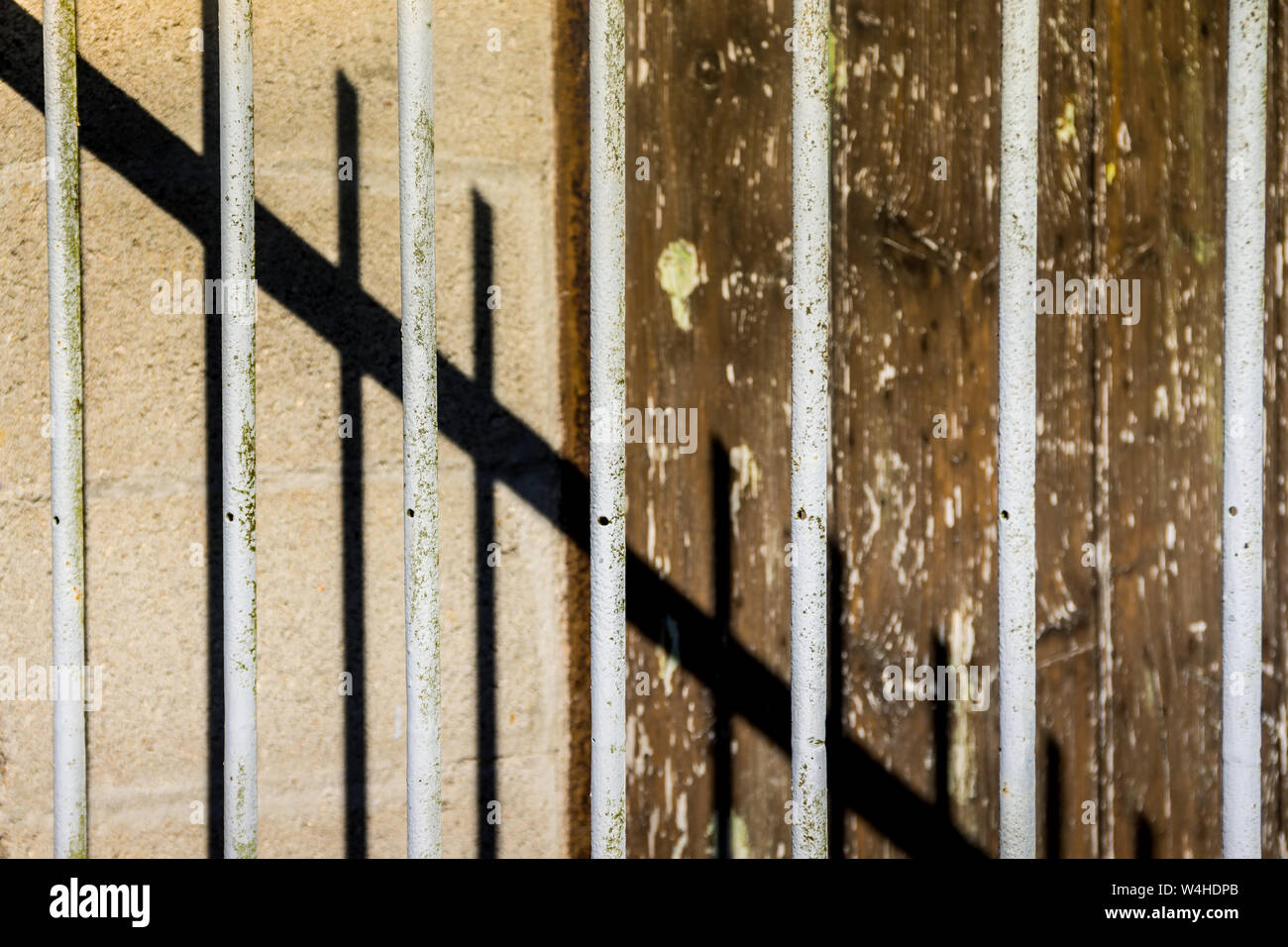 Old painted railings and corrugated wall with abstract shadows. Stock Photo