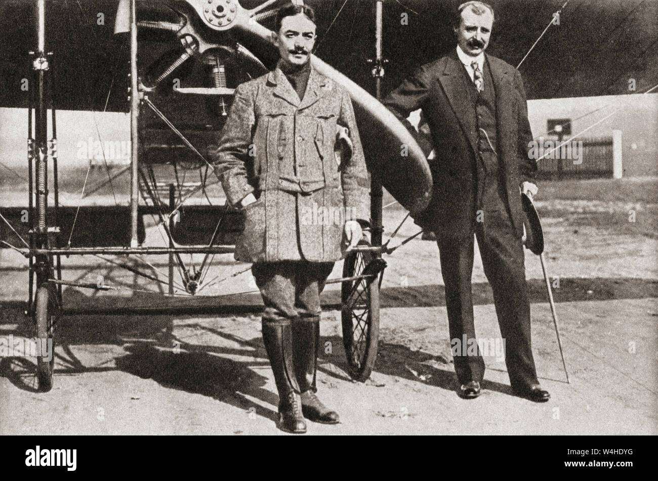 Monsieur Pegoud, left, and Monsieur Blériot, right, seen here at Brooklands flying school, Surrey, where the former had demonstrated his loop the loop in 1913.  Adolphe Célestin Pégoud, 1889 – 1915.  French aviator and flight instructor, the first fighter ace in history during World War I.   Louis Charles Joseph Blériot, 1872 – 1936.  French aviator, inventor and engineer.  From The Pageant of the Century, published 1934. Stock Photo