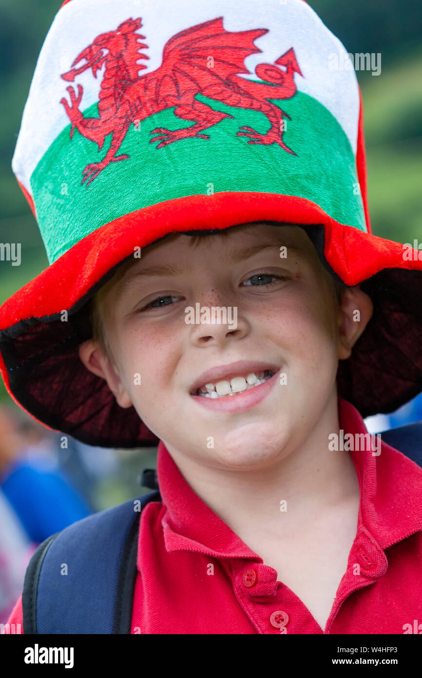 Young Welsh boy wearing a huge over-sized hat depicting the Welsh National Flag Stock Photo